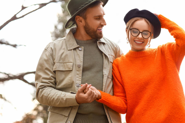 Feliz pareja de moda a pie en el parque de otoño - Foto, Imagen