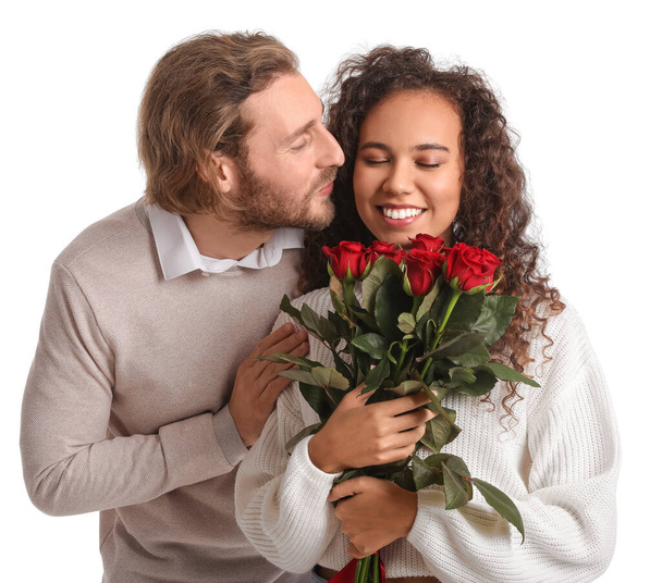 Feliz pareja joven con ramo de rosas sobre fondo blanco. Celebración de San Valentín - Foto, imagen
