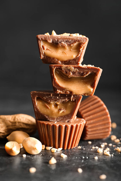 Gustose caramelle al cioccolato con burro di arachidi su sfondo scuro, primo piano - Foto, immagini