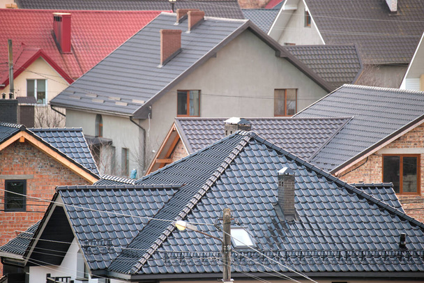 Residential houses with roof tops covered with metallic and ceramic shingles in rural suburban area - Photo, Image