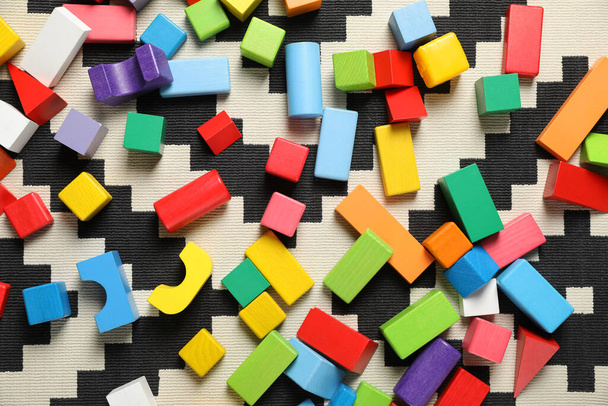 Colorful wooden building blocks on carpet, flat lay - Photo, image