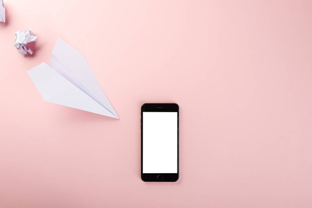 Paper plane letter document message. Top view mock up design of airplane travel and mobile phone, education or innovation origami plane with smartphone blank screen, isolated on pink background - Foto, Bild