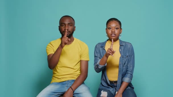 Hombre y mujer haciendo gesto de silencio con el dedo índice en la boca - Imágenes, Vídeo