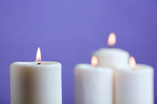grupo de velas con llama, y fondo violeta - Foto, Imagen