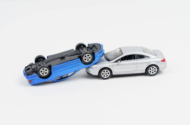 Occurrence. Collision of silver and blue toy cars. Isolated on white background. - Фото, изображение