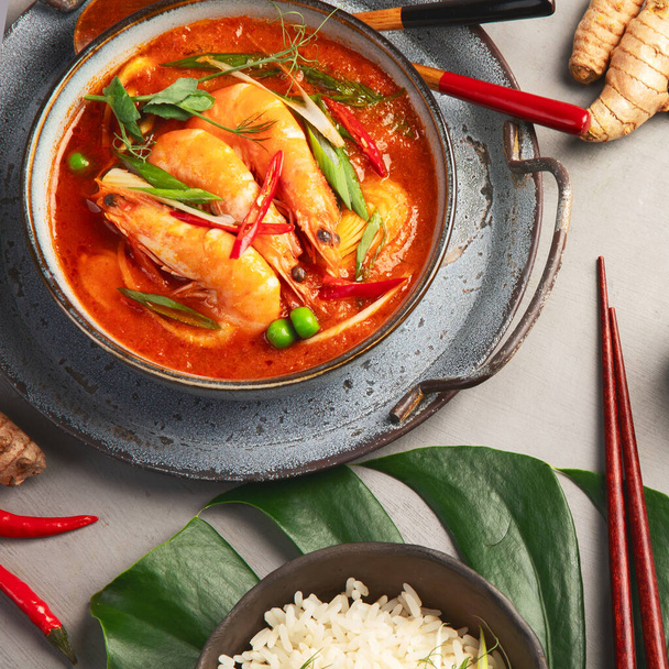 Red curry with chicken in bowl on light gray background. Traditional Asian food. Top view, flat lay, copy space - Foto, Imagem