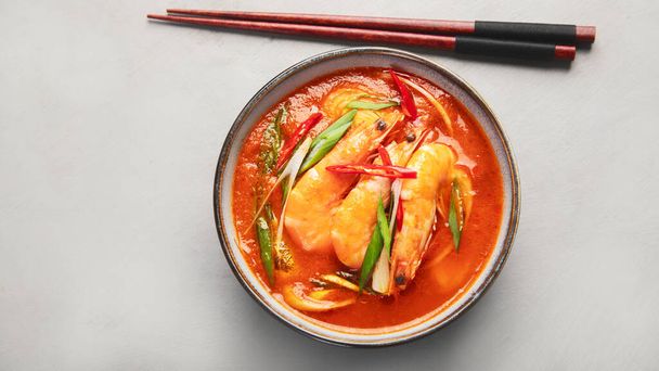 Curry vermelho com frango em tigela no fundo cinza claro. Comida asiática tradicional. Vista superior, flat lay, espaço de cópia - Foto, Imagem