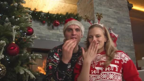 Fröhliches Paar tanzt und schickt Küsse, während es zu Hause Weihnachten feiert - Filmmaterial, Video
