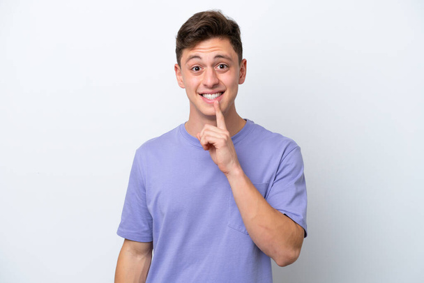 Young handsome Brazilian man isolated on white background showing a sign of silence gesture putting finger in mouth - Zdjęcie, obraz