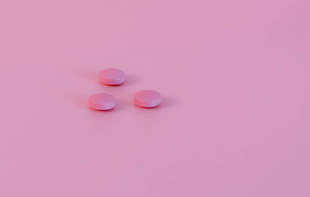 Pink tablets pill on pink background. Pharmacy banner. Pharmaceutical industry. Health care and medicine. Woman health insurance. Mood stabilizer pills. Happy pills. Vitamin and supplement concept. - Photo, image