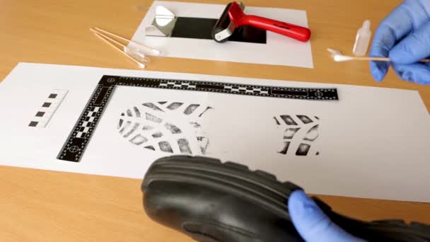  Ein wissenschaftlicher Polizeiermittler CSI entnimmt im Labor mit Tinte Proben der Schuhabdrücke - Filmmaterial, Video