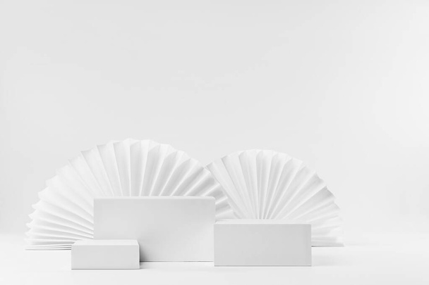 Set of three rectangle white podiums mockup with oriental paper fans as decor in modern minimal style, stage for presentation of cosmetic product or goods, advertising, design, copy space, front view. - Φωτογραφία, εικόνα