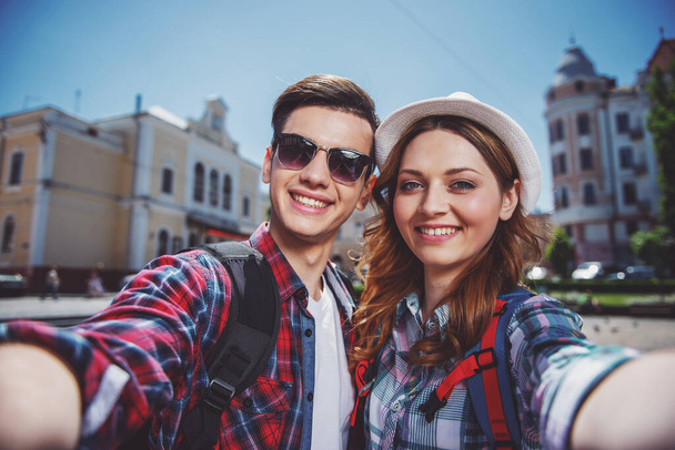 Счастливые путешественники фотографируются на улице старого европейского города
. - Фото, изображение