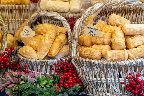 Παραδοσιακό πολωνικό καπνιστό τυρί "oscypek" σε μια χριστουγεννιάτικη αγορά stall στην Κρακοβία, Πολωνία. - Φωτογραφία, εικόνα