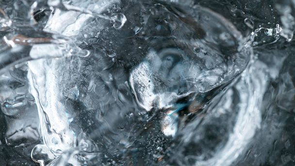 Detail shot of ice beying dropped into vodka drink. Super macro shot. - Foto, Bild