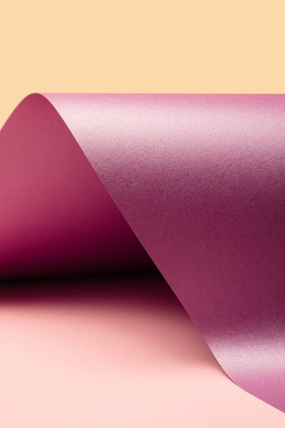 Violet rózsaszín hullám alakú, fémes világítás egy pasztell rózsaszín és sárga háttér. Minimális színes háttér - Fotó, kép