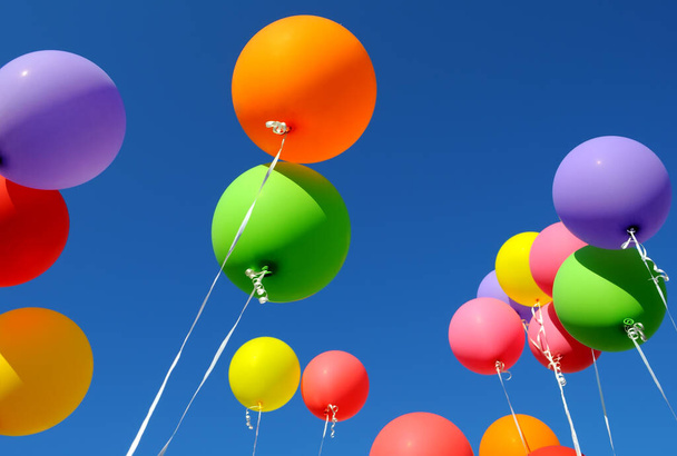 group of multicolored balloons in the city festival on clear blue sky background - Foto, Imagem
