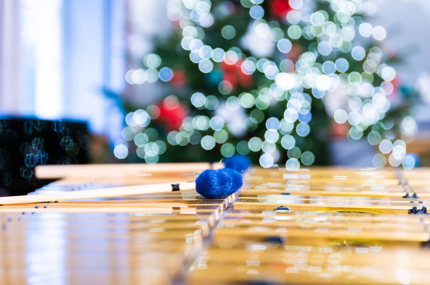Os bastões de vibrafone deitados neste instrumento de percussão. No fundo, luzes desfocadas e desfocadas da árvore de Natal. - Foto, Imagem