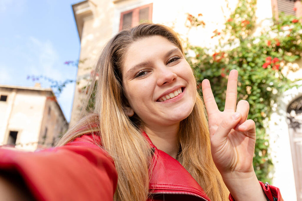 Uma jovem que viaja para Roma. Selfie de uma jovem mulher loira sorridente. Conceito de viagem e liberdade. - Foto, Imagem