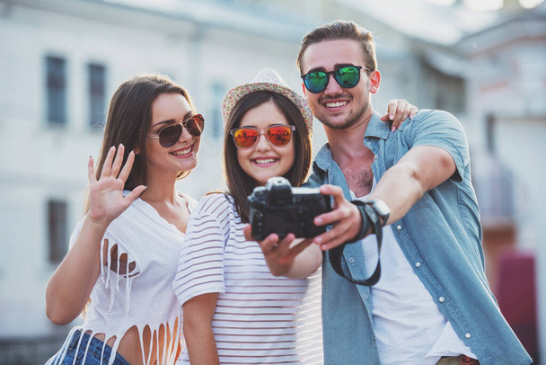 Přátelství, volný čas a lidé koncept. Mladí lidé berou selfie fotografií s fotoaparátem, venku, v městě. - Fotografie, Obrázek
