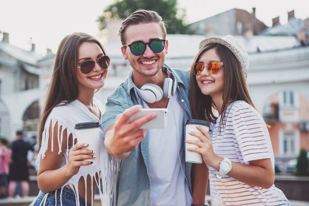 Amitié, loisirs, technologie et concept de personnes. Les jeunes prennent des photos selfie, à l'extérieur, en ville
. - Photo, image