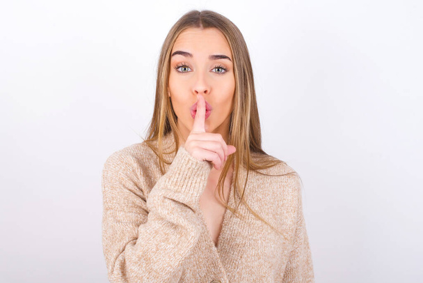 young woman making silence gesture, finger by mouth - Foto, imagen
