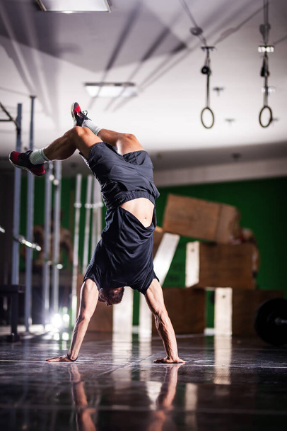 Muscular athlete standing and walking on hands upside down. - Valokuva, kuva
