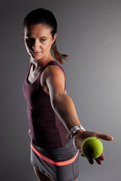 Professional female tennis player. Girl swinging racket preparing to serve - Fotoğraf, Görsel