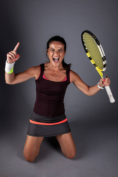 Professional female tennis player. Happy girl screaming with racket in hands. - Foto, afbeelding