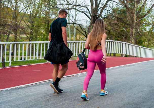 フィットネス、スポーツ、友情、健康的なライフスタイルのコンセプト-川の橋を渡るカップル - 写真・画像