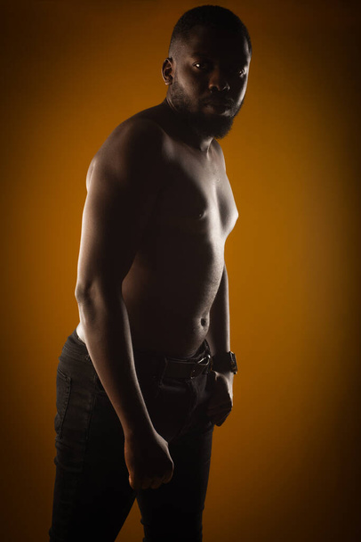 Topless et beau mec noir pose en studio sur fond jaune - Photo, image
