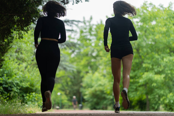 Two beautiful young girls are running together in the morning - Foto, Bild