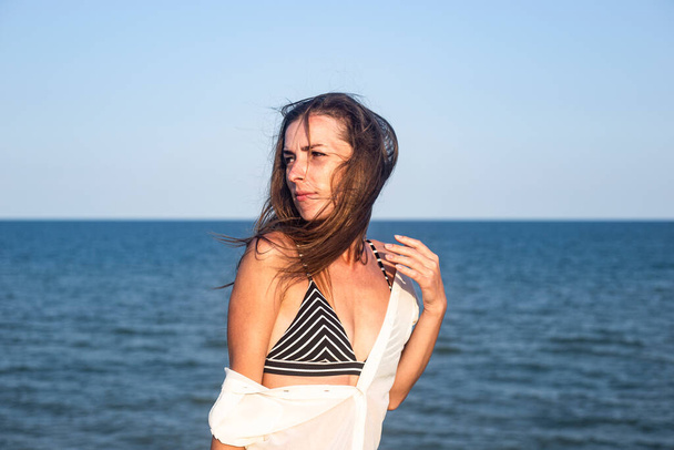 Сексуальная молодая женщина в легком парике на фоне моря  - Фото, изображение