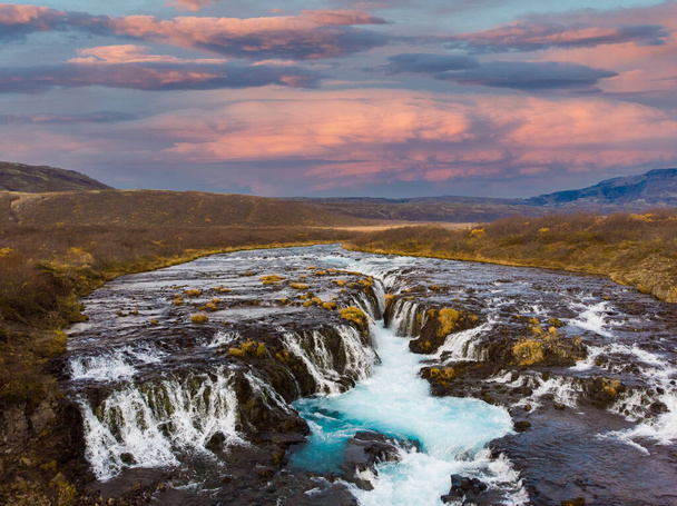 A cachoeira Bruarfoss na Islândia do Sul com um pôr do sol colorido uma água azul - Foto, Imagem