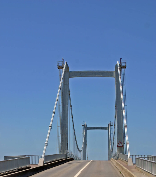 Uitzicht over een snelweg naar de steunbalken van een hangbrug - Foto, afbeelding