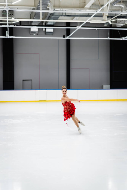プロのアイスアリーナで楽しい若い女性フィギュアスケートの完全な長さ - 写真・画像
