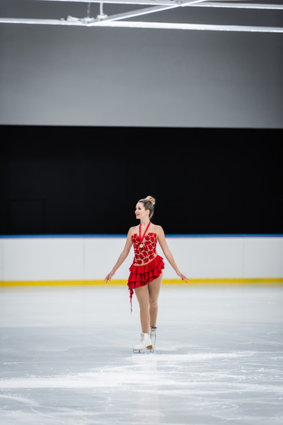 pełna długość szczęśliwej młodej kobiety z medalem łyżwiarstwo figurowe na profesjonalnej arenie lodowej - Zdjęcie, obraz
