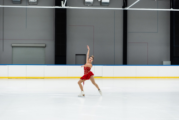 full length of young woman in dress figure performing dance in professional ice arena - Valokuva, kuva