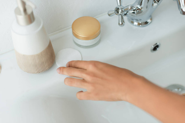 Vágott kilátás afro-amerikai nő vesz pamut pad mosdó a fürdőszobában  - Fotó, kép