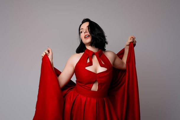 Uma sensual bela mulher de cabelos escuros posando em vestido vermelho - Foto, Imagem