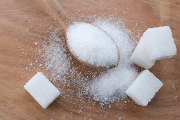 kristályszemcsés cukorszemcsék és fehér kockacukor háttér az asztalon - Fotó, kép