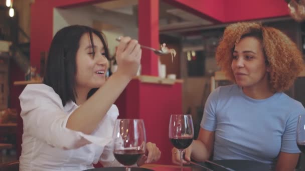 Aasialainen tyttö ravintolassa brasilialaisen ystävän kanssa nauti ateriasta - Materiaali, video