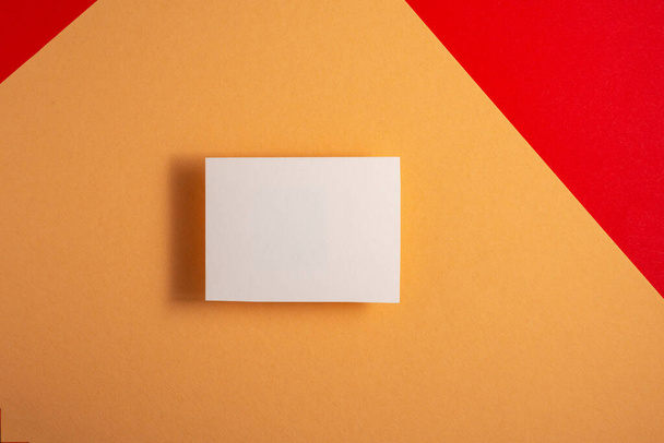 weiße Visitenkarten-Attrappe auf rotem und gelbem Hintergrund für Ihr Design . - Foto, Bild