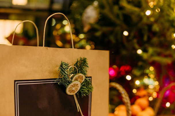 pacchetto vacanza regalo artigianale sotto l'albero di Natale con ghirlanda - Foto, immagini