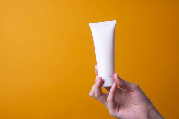 verpakking van handcrème in vrouwelijke handen - Foto, afbeelding