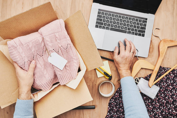 Business owner packing online order to delivery to customer. Preparing parcel box with clothes product from online shop - 写真・画像