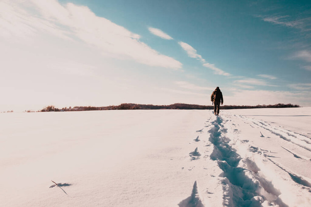 man wandelen op sneeuw in de winter landschap - Foto, afbeelding