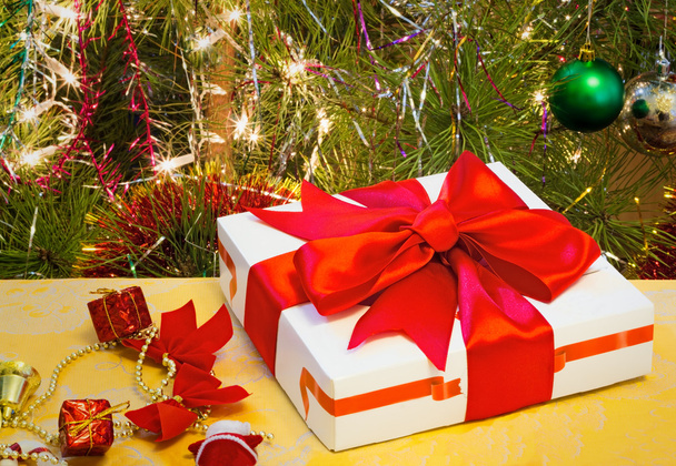 Kauniisti pakattu lahja jouluun ja koristeltu kuusipuu
. - Valokuva, kuva