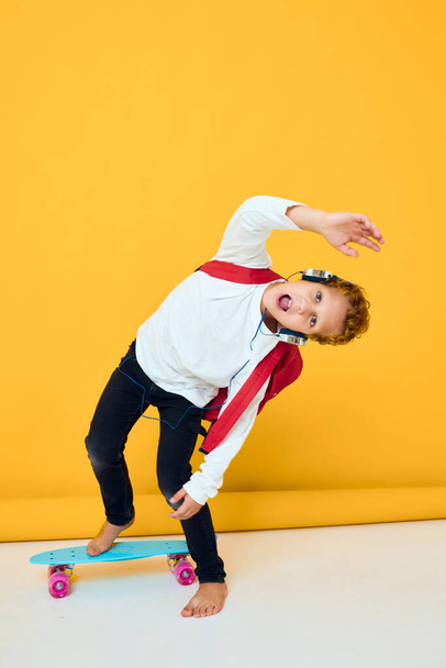portrét chlapce modrý skateboard sluchátka zábava izolované pozadí - Fotografie, Obrázek
