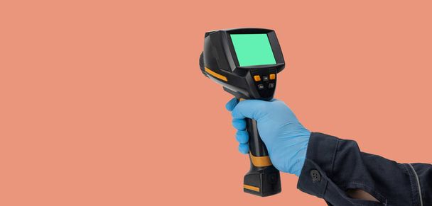 man in rubber gloves holds a thermographic camera. device for monitoring the temperature distribution of the surface under study. thermal imager in hand. Infrared thermography - Foto, immagini